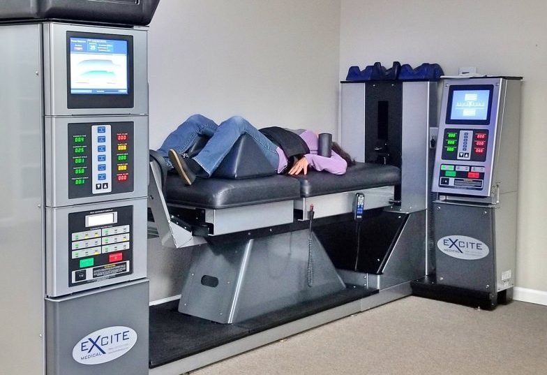 A patient uses the DRX9000 to perform non-surgical spinal decompression for lower back pain at Intouch Chiropractic